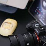 A modern desk setup featuring a camera, laptop, and mouse, ideal for photography enthusiasts.